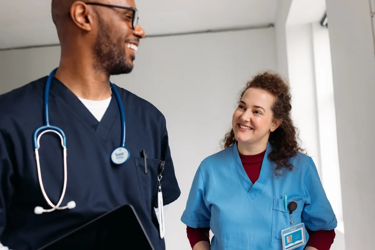 Two smiling healthcare workers in scrubs